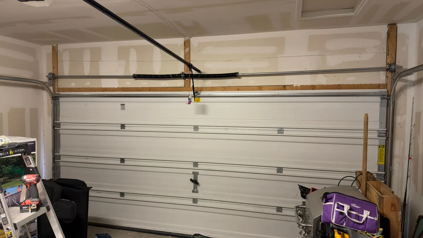 Interior view of a white sectional garage door, tracks, and overhead rail shown on the Why Austin Chooses Shockwave section on the homepage.