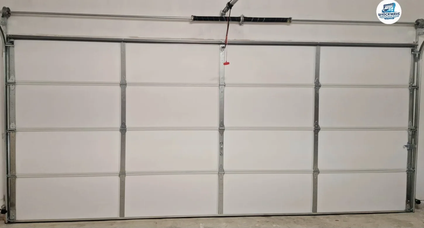 Full interior view of a white sectional garage door and overhead hardware in Shockwave's Austin-area work gallery.
